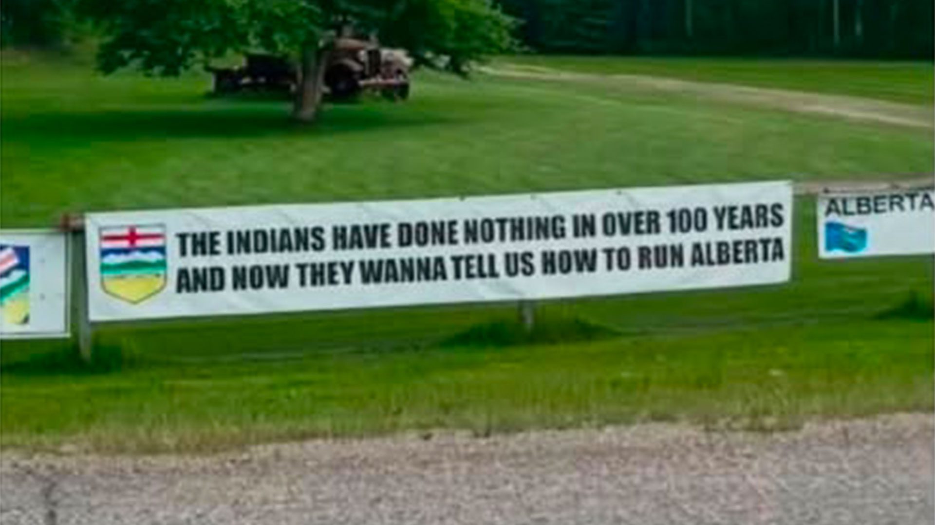 A banner hung on a fence near Spruce Grove, Alberta is drawing criticism from First Nations. Photo: Kara Burnstick/Facebook